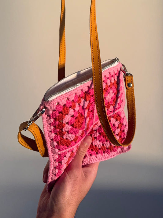 Handmade crocheted lined bag with leather strap.