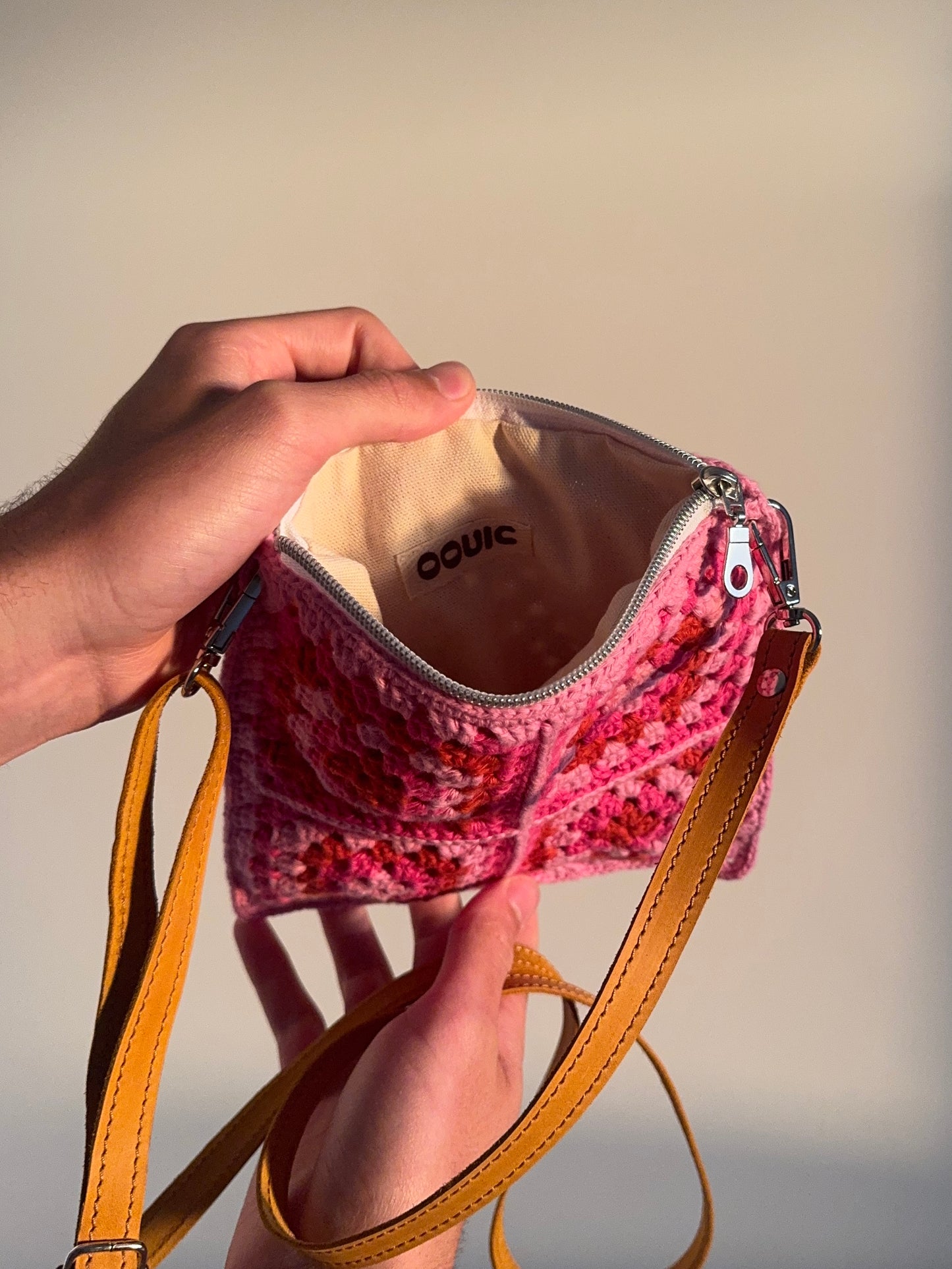 Handmade crocheted lined bag with leather strap.